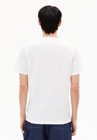 Weißes T-Shirt aus Baumwolle mit kurzen Ärmeln, Rundhalsausschnitt und glatter Textur. Die Rückansicht zeigt ein einfaches Design ohne Drucke oder Akzente.