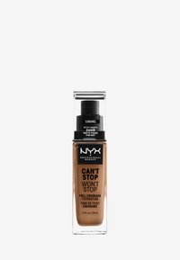Bouteille de fond de teint avec un corps rectangulaire transparent. L'étiquette indique "NYX Can't Stop Won't Stop," teinte "Caramel," finition mate, 30 mL. Capuchon noir à pompe.