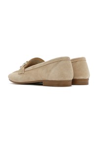 Mocassini in camoscio beige con tacco basso, dotati di un dettaglio a fiocco nella parte anteriore e semplici cuciture lungo i bordi.