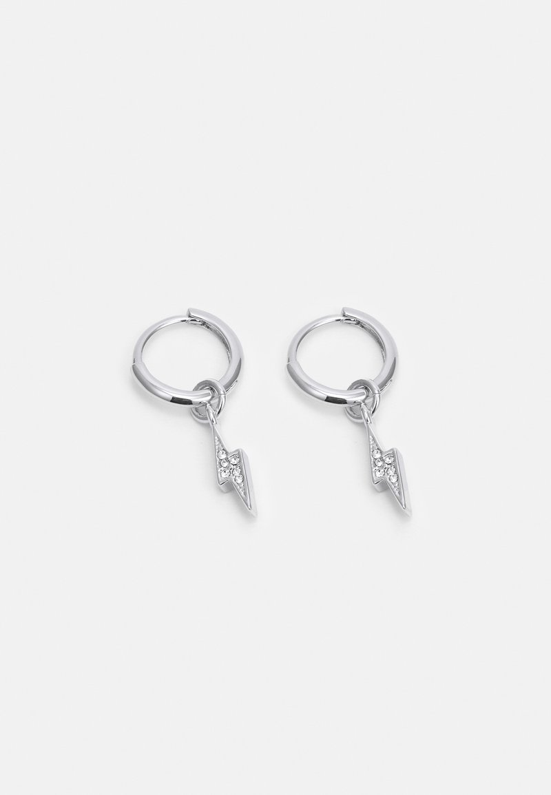 Boucles d'oreilles en argent en forme de créoles avec de petits pendentifs éclairs ornés de strass transparents sur un fond blanc uni.