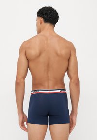 Μπλε βαμβακερές σλιπ εσώρουχες με εφαρμοστό σχέδιο και ριγέ ελαστική ζώνη στη μέση με κόκκινες, λευκές και μπλε λεπτομέρειες.