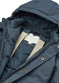 Tamno plavi zimski kaput s kapuljačom, zlatnim detaljima i bež podstavom. Sadrži etiketu s natpisom "MARMAR Copenhagen Outerwear."