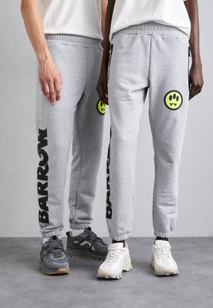 Gray sweatpants with black "BARROW" logo and a yellow smiley face patch. Features include elastic waistband and cuffed ankles.