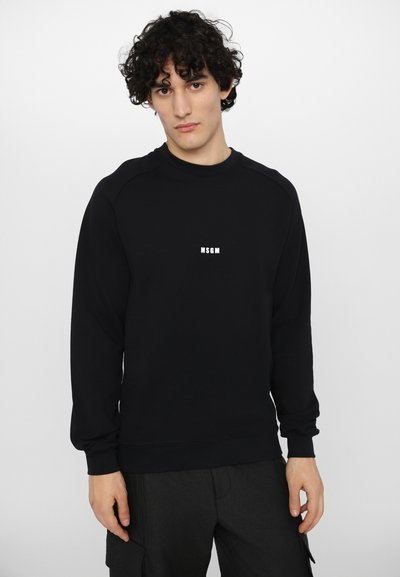 Sweatshirt noir avec des poignets et un ourlet côtelés, affichant un logo "MSGM" imprimé en blanc sur la poitrine. Tissu doux et manches raglan.