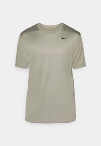 Camiseta de manga corta verde oliva claro, hecha de una tela suave, con un cuello redondo y un pequeño logo negro de Nike en el pecho.