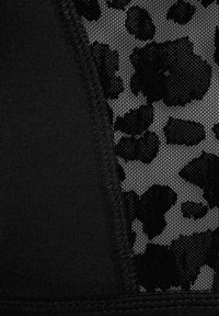 Black and gray fabric with a mesh section featuring a black leopard print pattern, complemented by solid black sections and textured edges.