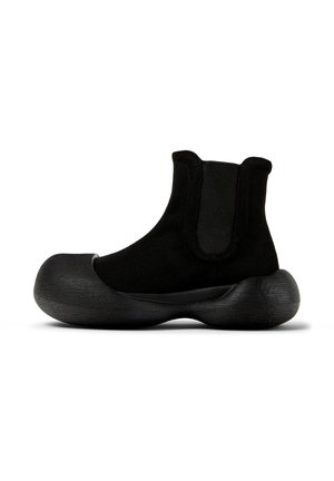 Schwarze Knöchelboots aus Stoff mit einer strukturierten, großen Gummisohle. Verfügt über elastische seitliche Einsätze für ein einfaches An- und Ausziehen. Modernes, einzigartiges Design.