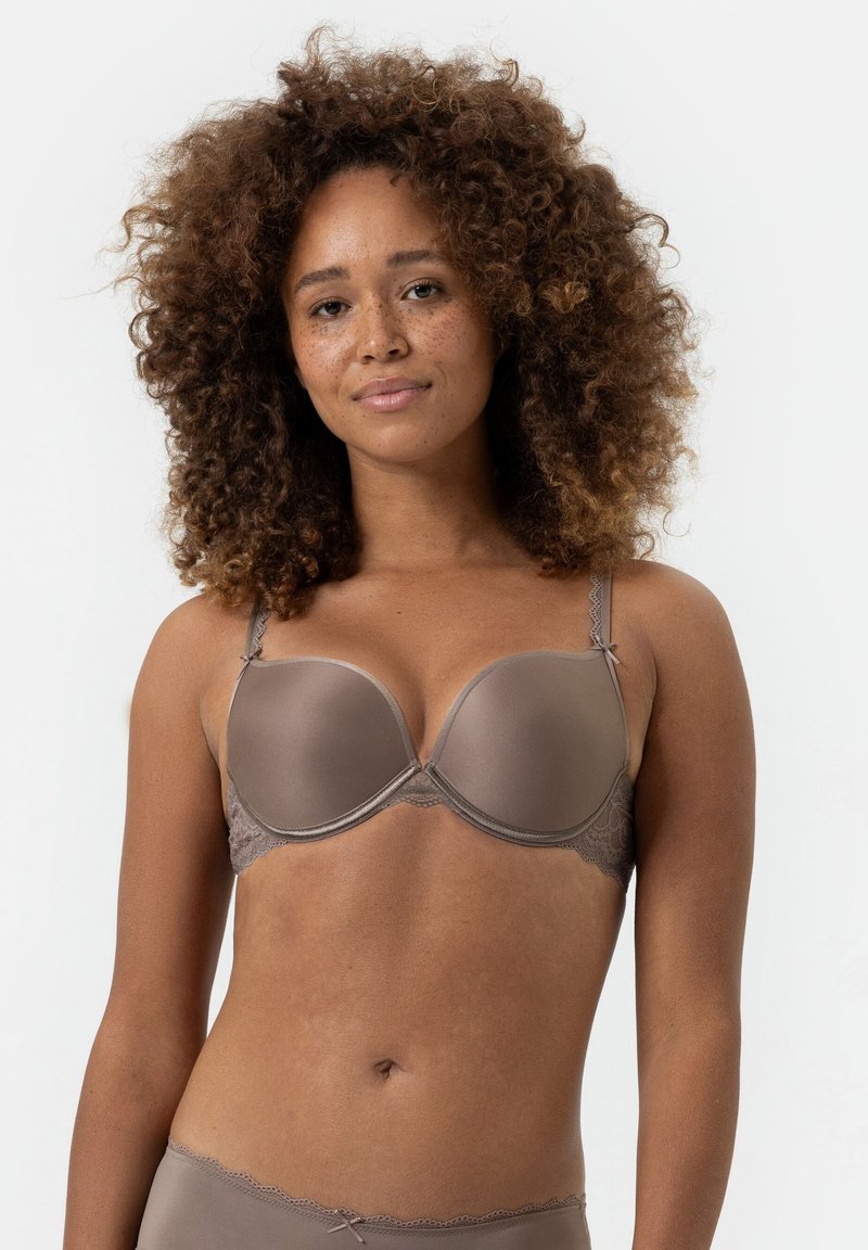 Bra in Braun mit Polsterung und Spitze, ausgestattet mit verstellbaren Trägern und einer glatten, glänzenden Oberfläche. Das Design umfasst ein dekoratives Schleifchen.