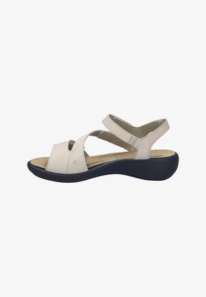 Beige leather sandals with cross straps, padded footbed, and a dark sole. Features a smooth texture and adjustable straps for fit.