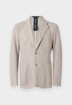 Blazer beige texturé pour homme avec revers crantés, deux boutons devant, poches plaquées, poche poitrine et étiquette JOOP! JEANS visible à l'intérieur du col.