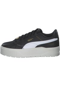 Sneaker atletici bianco e nero realizzati in pelle con una spessa suola in gomma bianca, caratterizzati da dettagli dorati e lacci neri.