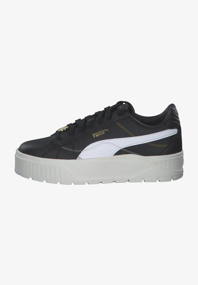 Sneaker atletici bianco e nero realizzati in pelle con una spessa suola in gomma bianca, caratterizzati da dettagli dorati e lacci neri.