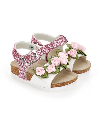 Sandalias blancas con suelas de corcho, con tiras de purpurina rosa y decoraciones de rosas falsas en la parte frontal. Hebilla plateada ajustable para la tira.