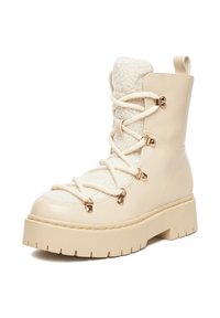 Botă de iarnă bej, cu platformă, talpă texturată groasă, căptușeală din fleece, șireturi încrucișate și mov de aur, văzută din unghiul frontal drept.