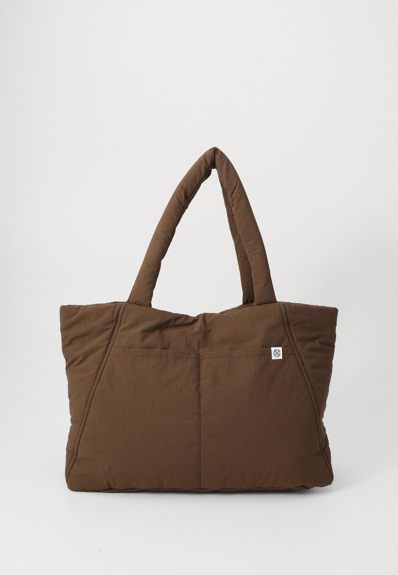 Borsa a tracolla marrone trapuntata con due manici, forma rettangolare, cuciture sottili e un piccolo tag con il logo sul lato. Texture del tessuto morbida.