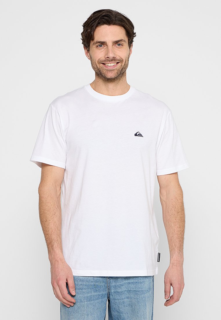 Camiseta blanca de manga corta hecha de algodón, con un pequeño logo negro en el lado izquierdo del pecho y un cuello redondo. Diseño de ajuste clásico.
