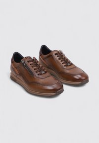 Zapatillas de cuero marrón con puntera redondeada, cierre de cordones en la parte delantera y cremallera lateral. Presentan una suela texturizada y un acabado suave. Costuras de acento visibles.