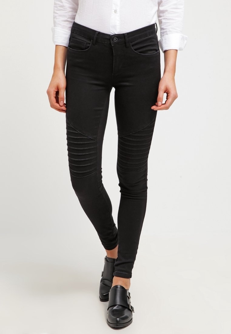 Jean skinny noir avec un détail de panneaux côtelés sur les cuisses, fabriqué en tissu extensible. Comprend un design classique à cinq poches et une fermeture à glissière.