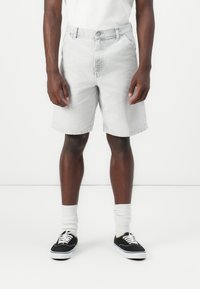 Light gray denim shorts with a straight cut, five pockets, and a button closure. Worn with white crew socks and black sneakers.