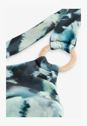 Mnohobarevná tkanina s batikovaným vzorom v odtieňoch modrej a zelenej; zlaté kruhové kovanie ako akcent na dekolte.