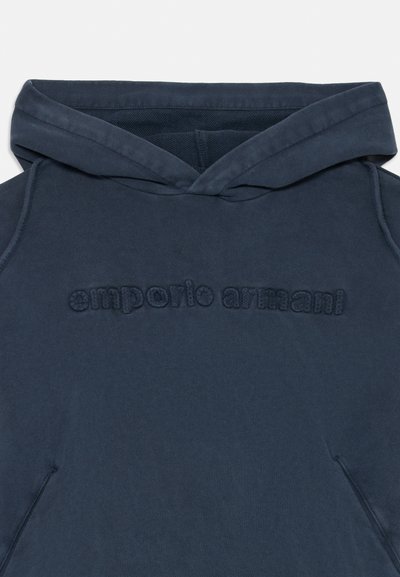 Navy plavi dukserica s kapuljačom od mekog materijala, s reljefnim logotipom "emporio armani" na prednjoj strani i klasičnom kengur polovinom.