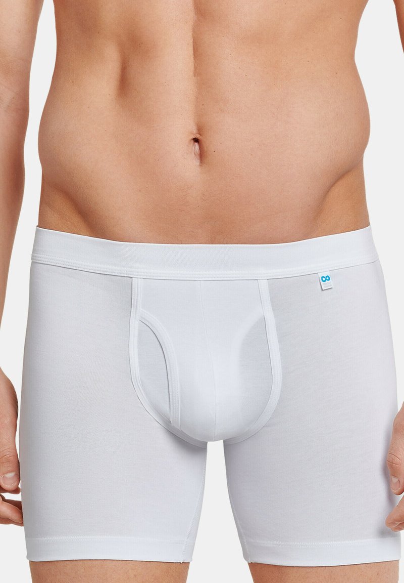 Boxer in cotone bianco con vestibilità aderente, dotati di una tasca frontale funzionale e un elastico in vita con un piccolo logo blu.