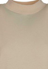 Beige crew neck, long-sleeve top with smooth fabric and visible stitching along the neckline.