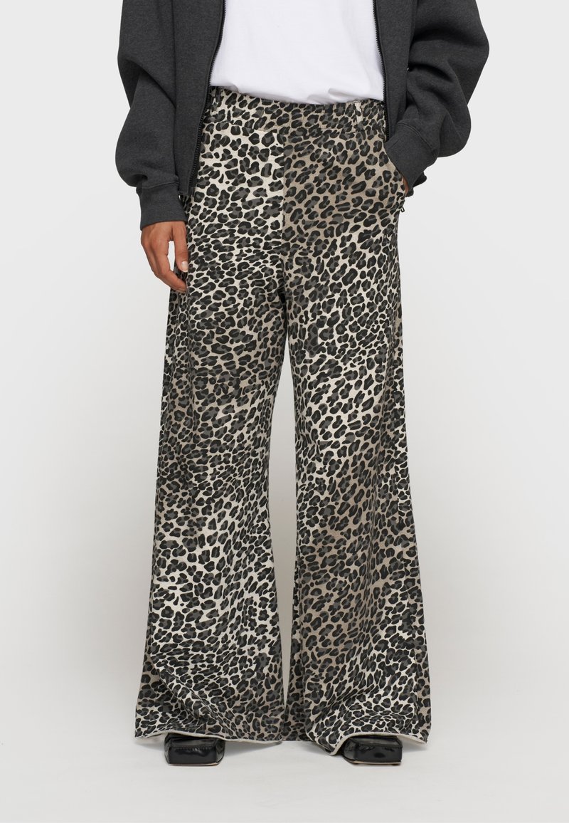 Pantaloni a gamba larga con stampa leopardata in beige e nero. Caratterizzati da una vita alta e tasche, realizzati in un tessuto liscio e leggero.