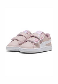 Baskets rose clair avec deux bandes Velcro, accents blancs, bout arrondi et graphiques ludiques de cœurs et d'un personnage sur le côté.