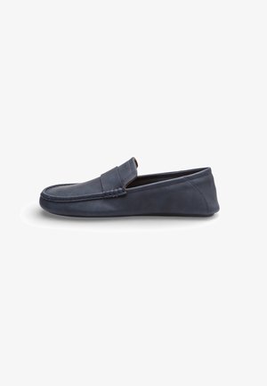 Mocassino slip-on in pelle scamosciata blu navy con cuciture moc toe e tacco basso, mostrato in profilo laterale su sfondo bianco.