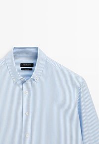 Lyseblå stribet bomuldsskjorte med knaplukning ved kraven, hvide knapper og en blød tekstur med en figursyet pasform.
