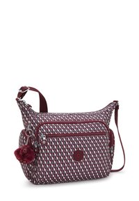 Borsa a tracolla a motivo marrone e grigio con molteplici tasche con zip e un piccolo portachiavi a forma di scimmietta in peluche marrone attaccato.
