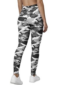 Leggings u crno-bijelo-sivoj kamuflažnoj uzorku, s visokim strukom i tijesnim krojem, izrađene od glatkog, rastezljivog materijala.