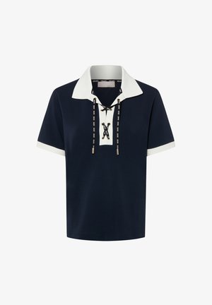 Marineblaues Poloshirt mit weißem Kragen und weißen Ärmeln. Verfügt über eine Schnürung vorne mit schwarz-weißen Schnurdetails und metallischen Endhülsen.