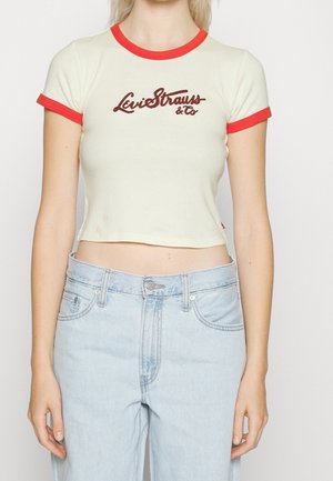T-shirt court crème avec col et manches à bordure rouge, arborant un logo brodé "Levi Strauss & Co" marron sur le devant.