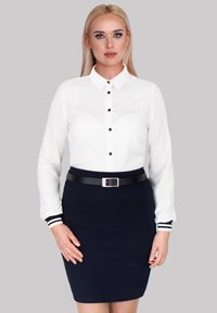 White blouse with long sleeves, black buttons, and a navy pencil skirt with black belt. Skirt features a smooth texture and solid color.