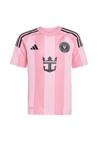 Maillot de football rose clair avec des rayures verticales noires, col rond et manches courtes. Comprend un blason noir et la marque "Adidas". Texture en maille.