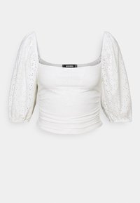 White top with a square neckline, puffed short sleeves, ruching at the waist, and eyelet details throughout the fabric.