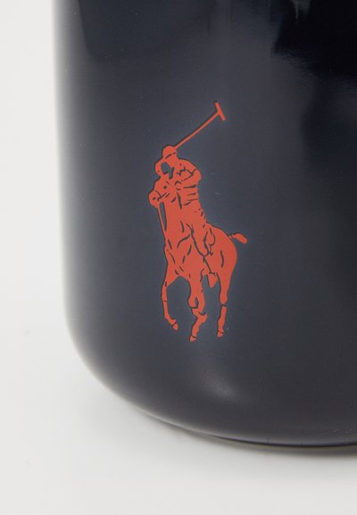 Námornícky keramický hrnček s lesklým povrchom, ktorý zobrazuje veľkú grafiku červeného pólo hráča. Hladký povrch, okrúhly tvar a žiadny viditeľný kovový prvok.