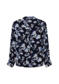 Blusa a maniche lunghe in tessuto blu navy con motivi floreali bianchi e blu. Presenta un passante posteriore e due tasche superiori nella parte posteriore.