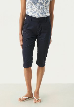 Pantaloni corti navy fino al ginocchio realizzati in cotone con una texture liscia e una vestibilità su misura. Presentano una chiusura frontale a gancio e tasche laterali.