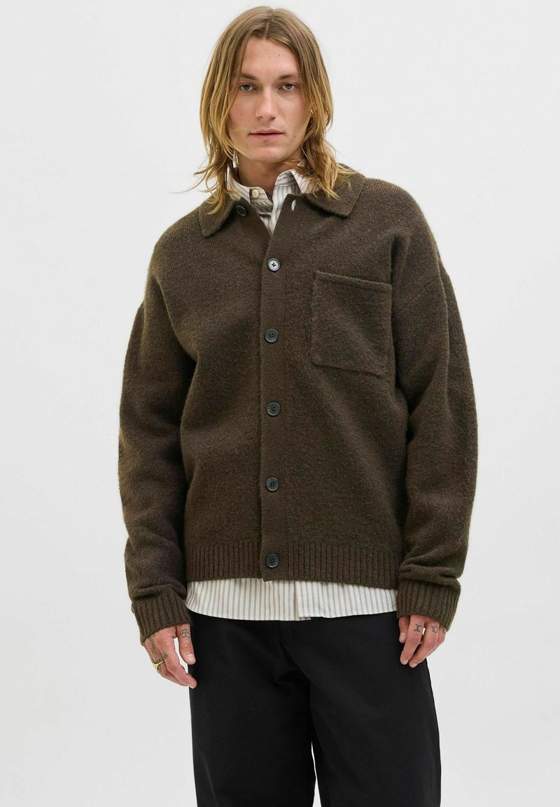 Brown wool cardigan with a collared neck, front buttons, a single chest pocket, and ribbed cuffs; layered over a striped shirt.