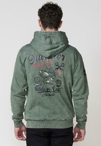 Zelená mikina s kapucňou a textúrovaným povrchom s grafickým potlačou kostry na motocykli, textom "Racer Team" a "Ride or Die."