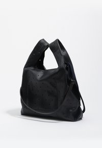 Czarna skórzana torba z perforacjami, miękkim kształtem, pojedynczym paskiem na ramię, teksturowaną powierzchnią oraz kontrastującym granatowym wnętrzem.