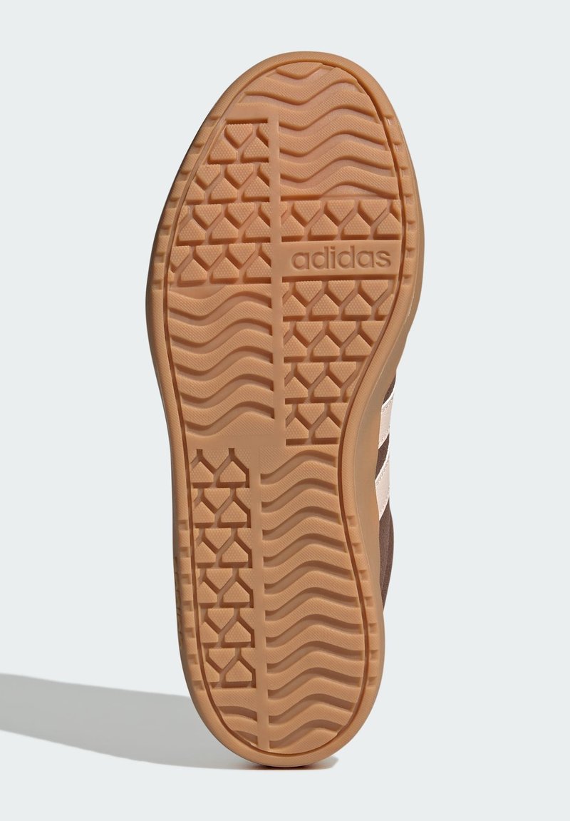 Adidas schoenzool met een golvend profiel van rubber. De kleur is bruin met subtiele branding en een gestructureerd oppervlak voor grip.