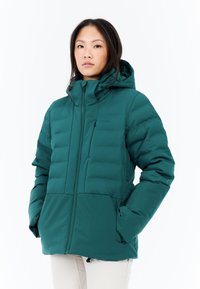 Tyrkysová péřová bunda se zapínáním na zip, vyvýšeným límcem a nastavovací kapucí. Má prošívanou texturu, nastavení pomocí šňůrek a boční kapsy.