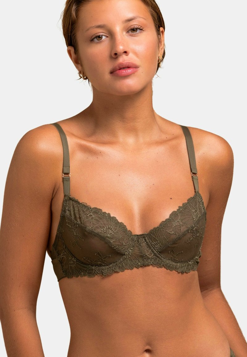 Soutien-gorge en dentelle vert olive avec un délicat motif floral, en tissu en mesh transparent, bretelles ajustables et bords festonnés.