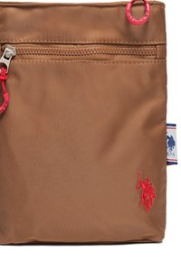 Borsa in nylon marrone con chiusura superiore a zip, tirazip rosso e logo ricamato in rosso sulla parte anteriore inferiore, con etichetta del marchio sul lato.