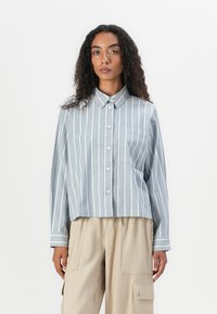 Lichtblauw gestreept overhemd met knopen, met een cropped ontwerp, lange mouwen, een kraag en een linker borstzak. Satijnachtige textuur en een gladde afwerking.