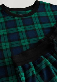 Grøn og marineblå ternet pyjamas sæt, der har en trøje med rund hals og bukser med snoretræk, med sorte ribbede detaljer ved halsudskæringen og taljen.